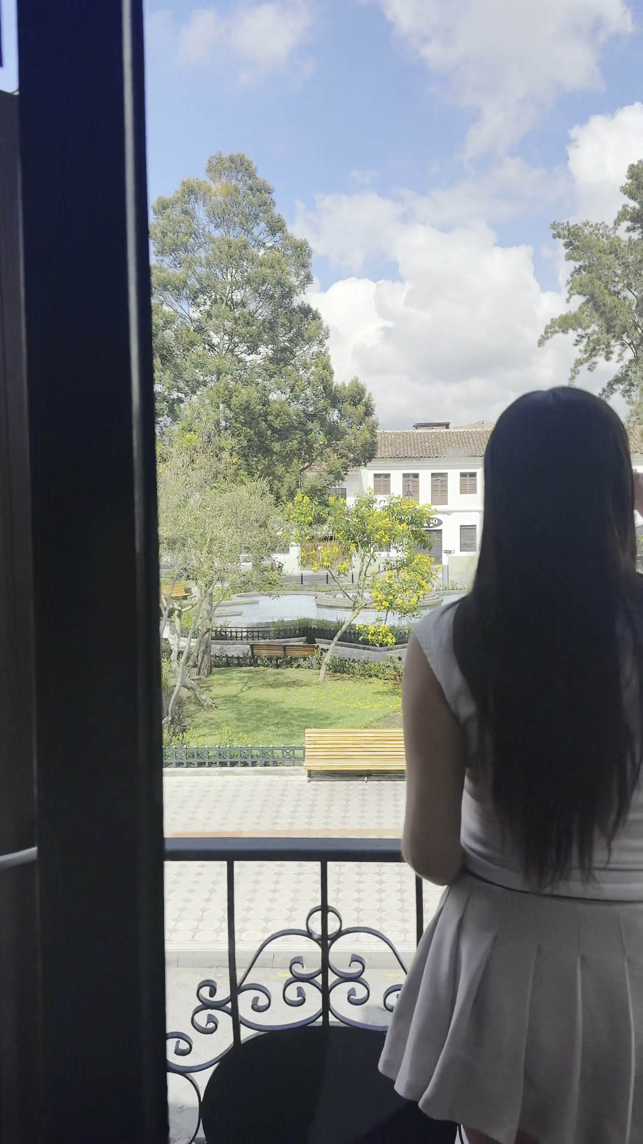 Huésped en el balcón mirando la plaza y los árboles del Centro Histórico